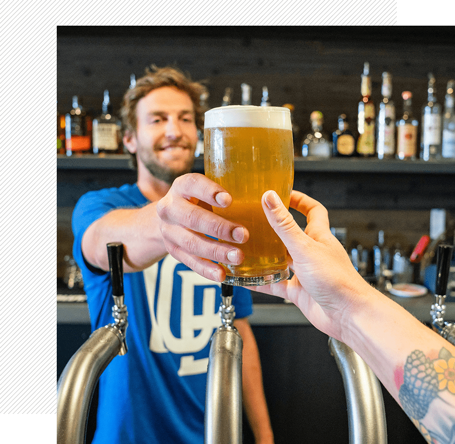 Bartender serving a glass of beer.