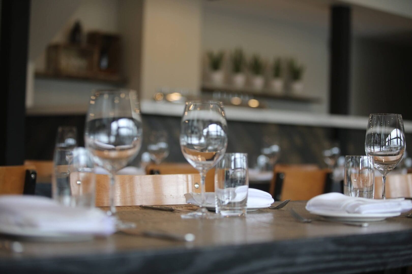 A table with wine glasses and water glasses on it.